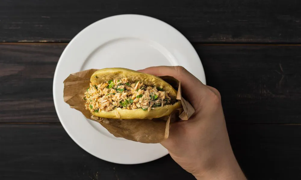 Hand-held braised pork bun wrapped in brown parchment paper at Good Alley, a Chinese restaurant in Arcadia